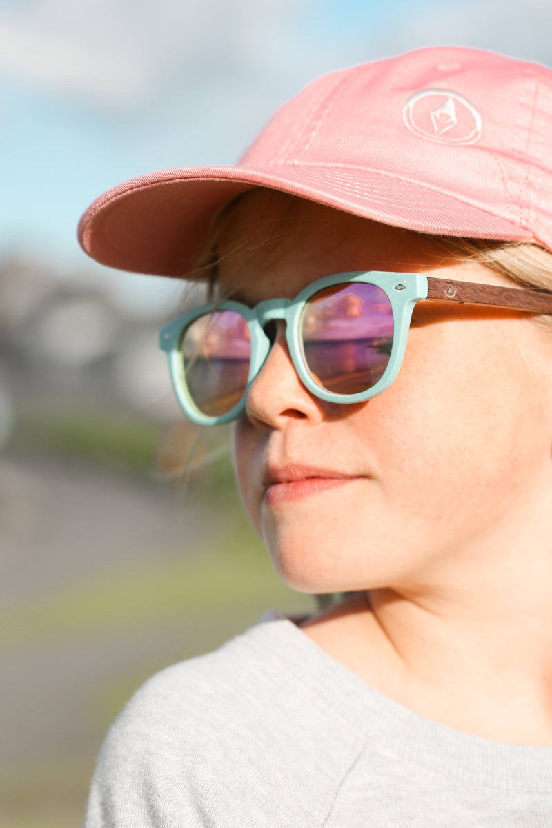 Made with a sustainable speckled wheatstraw frame with walnut wood temples, it's lightweight and comfortable. Fitted with UV400 polarised lenses. Our large child/teen/small adult frame and provides a neater fit without compromising on eye protection.