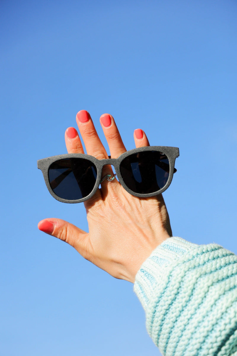 Made with sustainable speckled charcoal wheat straw or coffee residue frame and walnut wood temples, these stylish shades are lightweight, comfortable and eco-friendly with their plastic alternative materials. Fitted with UV400 polarised lenses in a smoke black colour and subtle logo is engraved on the temples. Sunglasses come with a padded pouch and microfibre cleaning cloth.